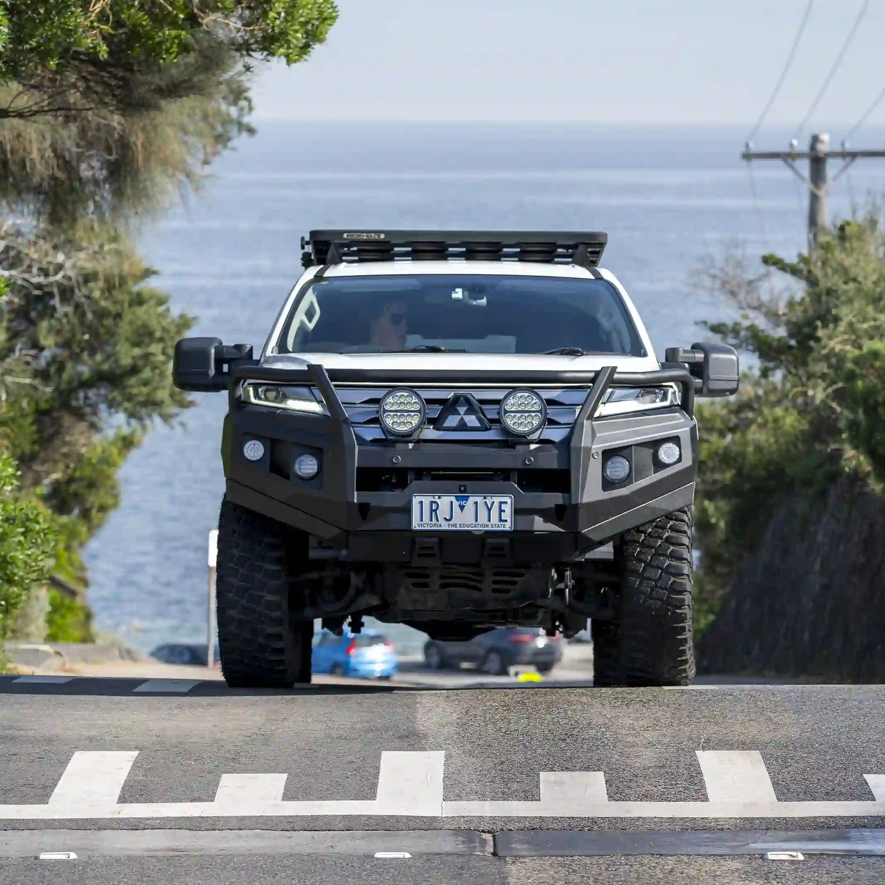 front view of mitsubishi pajero sport fitted with raxar loop type bull bar featuring adr compliance bumper replacement design recovery points and durable matte black finish engineered for maximum offroad protection and style available across australia from elevated 4x4
