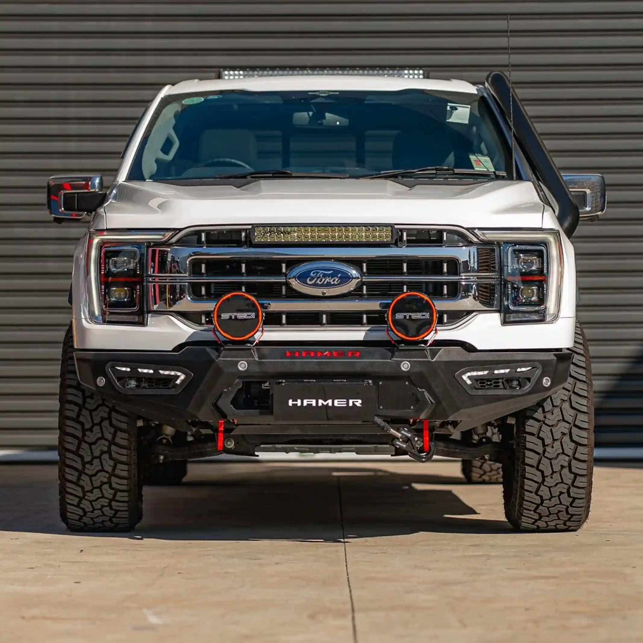 front installed view of ford f150 2021 fitted with atlas series bull bar showing matte black powder coat adr compliance and integrated sequential led lighting elevated 4x4