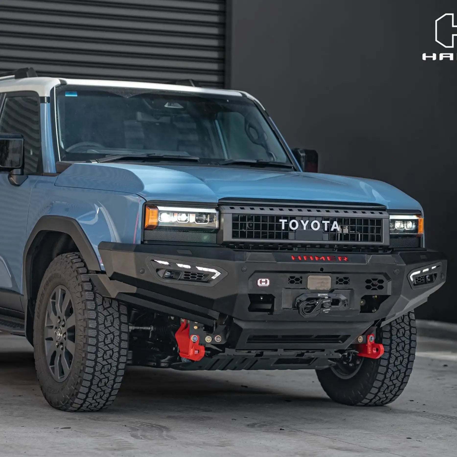 Left side angle of Hamer Atlas Series Bull Bar for Toyota Prado 250 Series 2024 – Present, highlighting matte black powder-coated finish, recovery points, and parking sensor compatibility.
