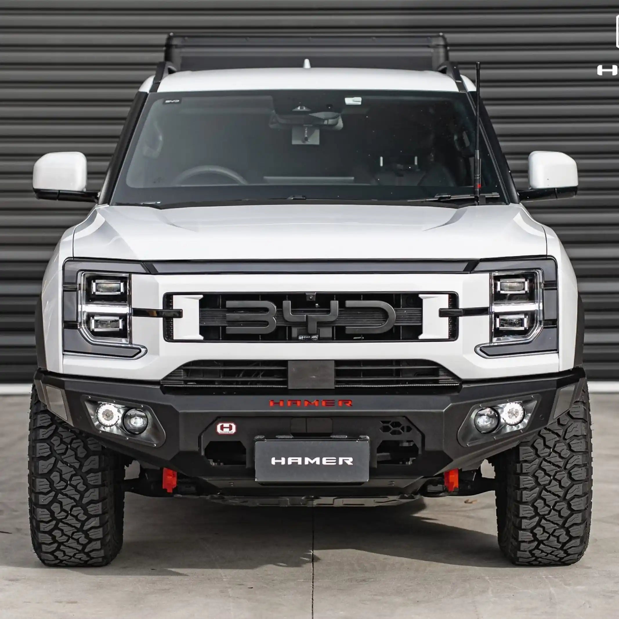 installed front angle of hamer king bull bar for byd shark 6 highlighting winch mount drl fog lights and recovery points elevated 4x4