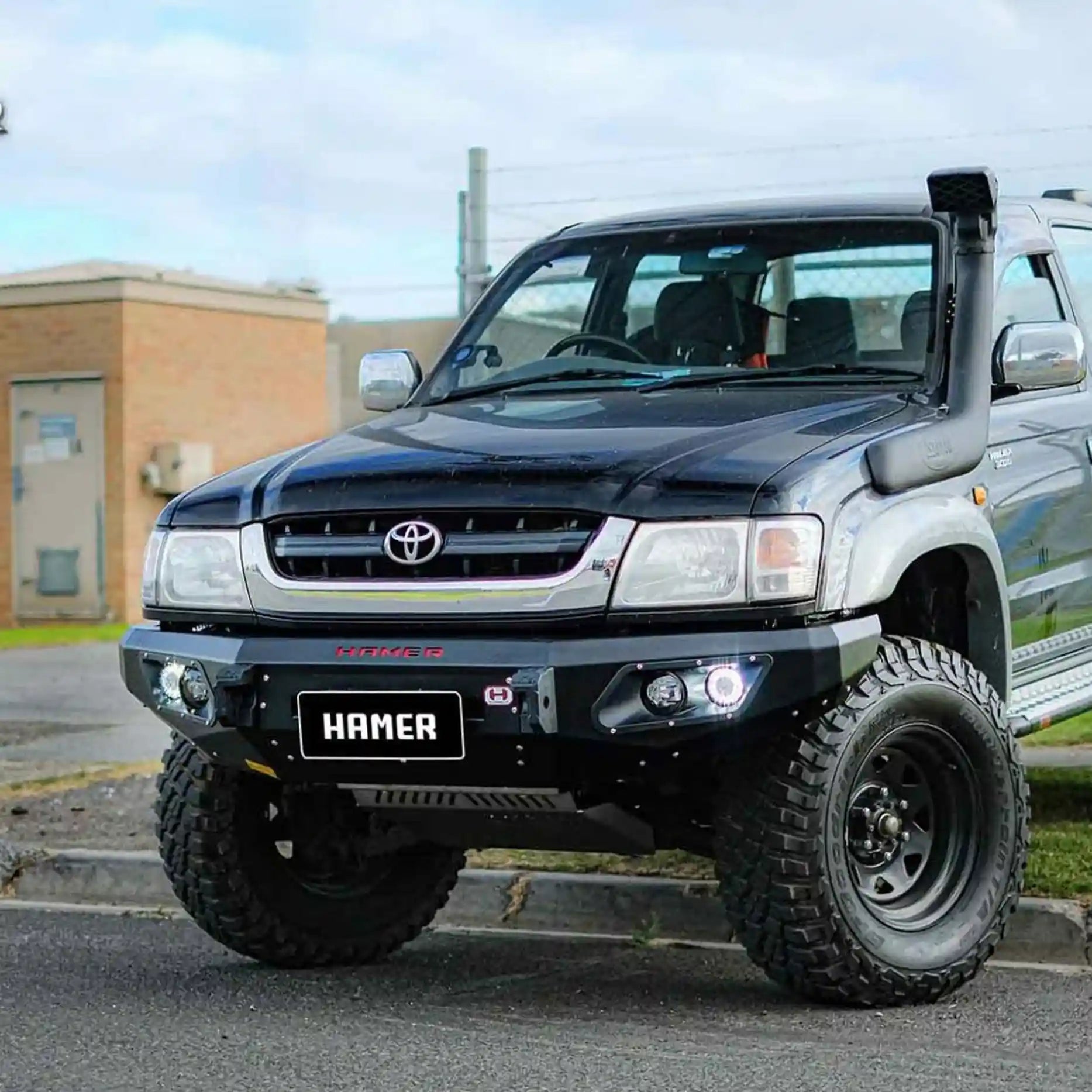 Right side view of Toyota Hilux 1997–2005 with Hamer King Bull Bar, durable 3mm steel, matte finish, LED fog and indicators.