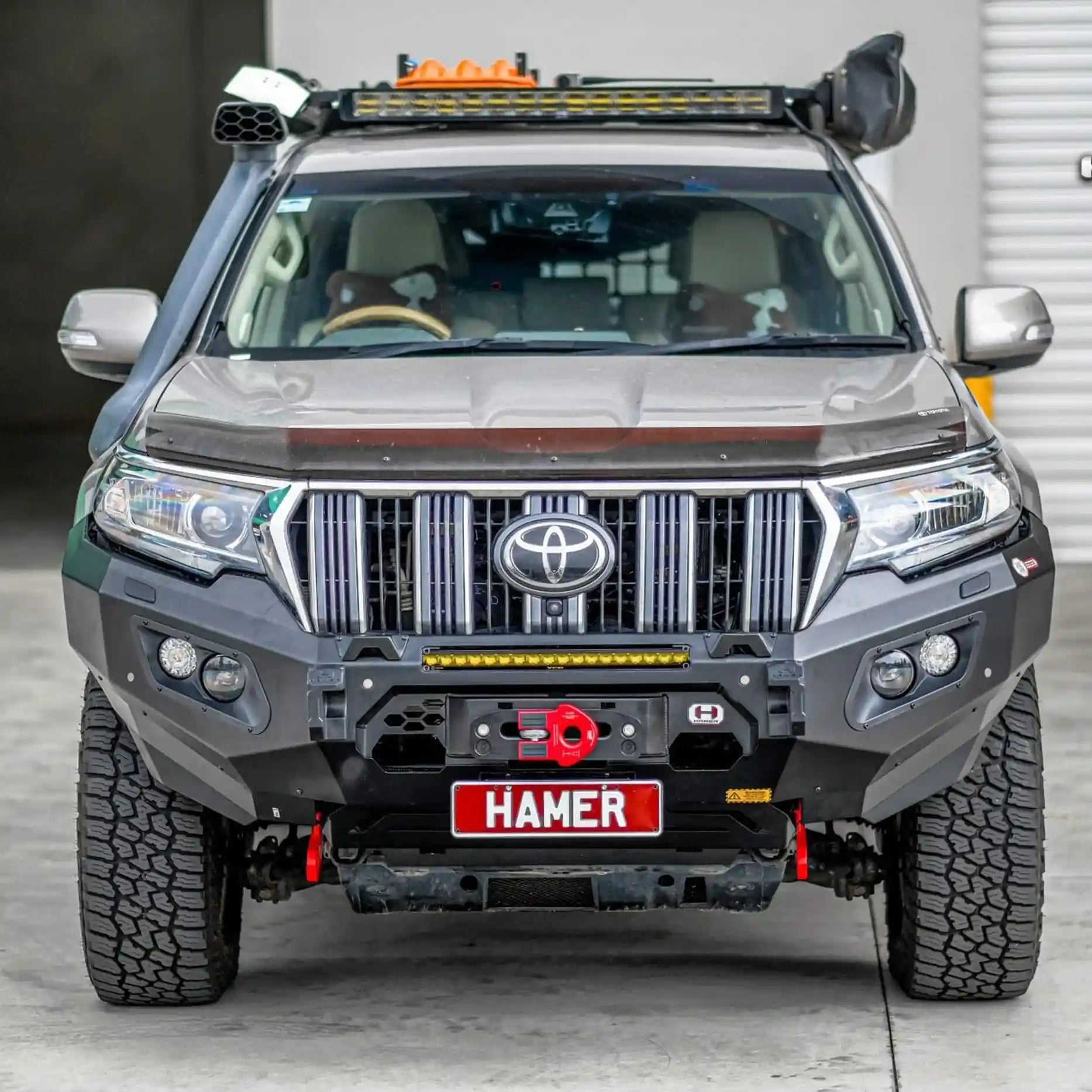 Front angle of Prado 150 Series showcasing Hamer King Bull Bar with integrated LED lights and winch compatibility.