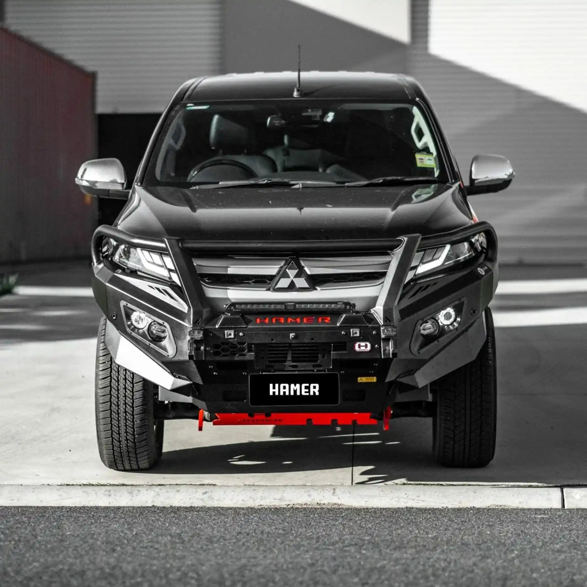 Front angle of Mitsubishi Triton MR fitted with Hamer King Plus Bull Bar, rugged matte black finish with fog lamps and recovery points.