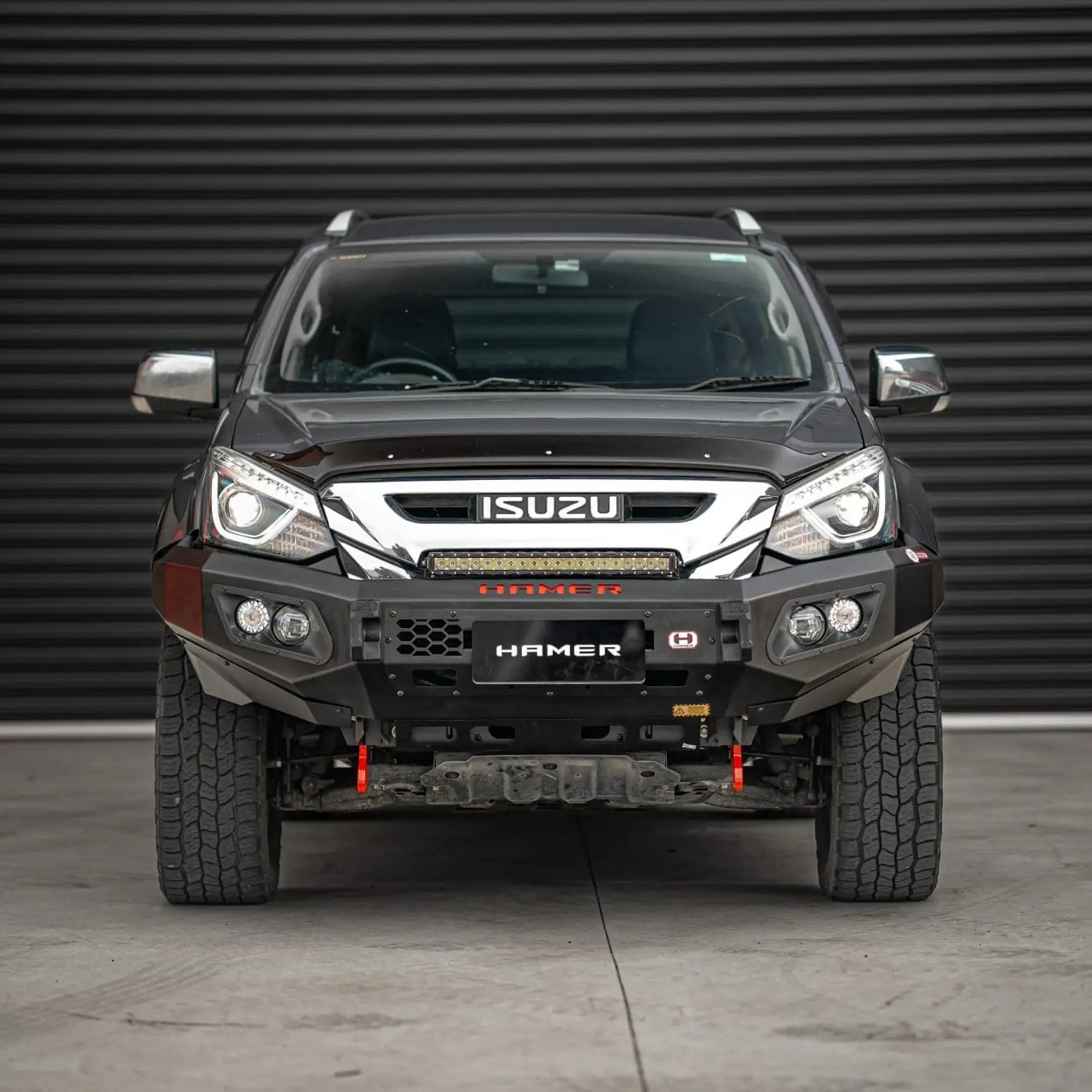 Front view of Isuzu MU-X 2016–2020 fitted with Hamer King Series Bull Bar, showing matte black powder-coated finish, ADR / Airbag compliance, and integrated LED lighting system.