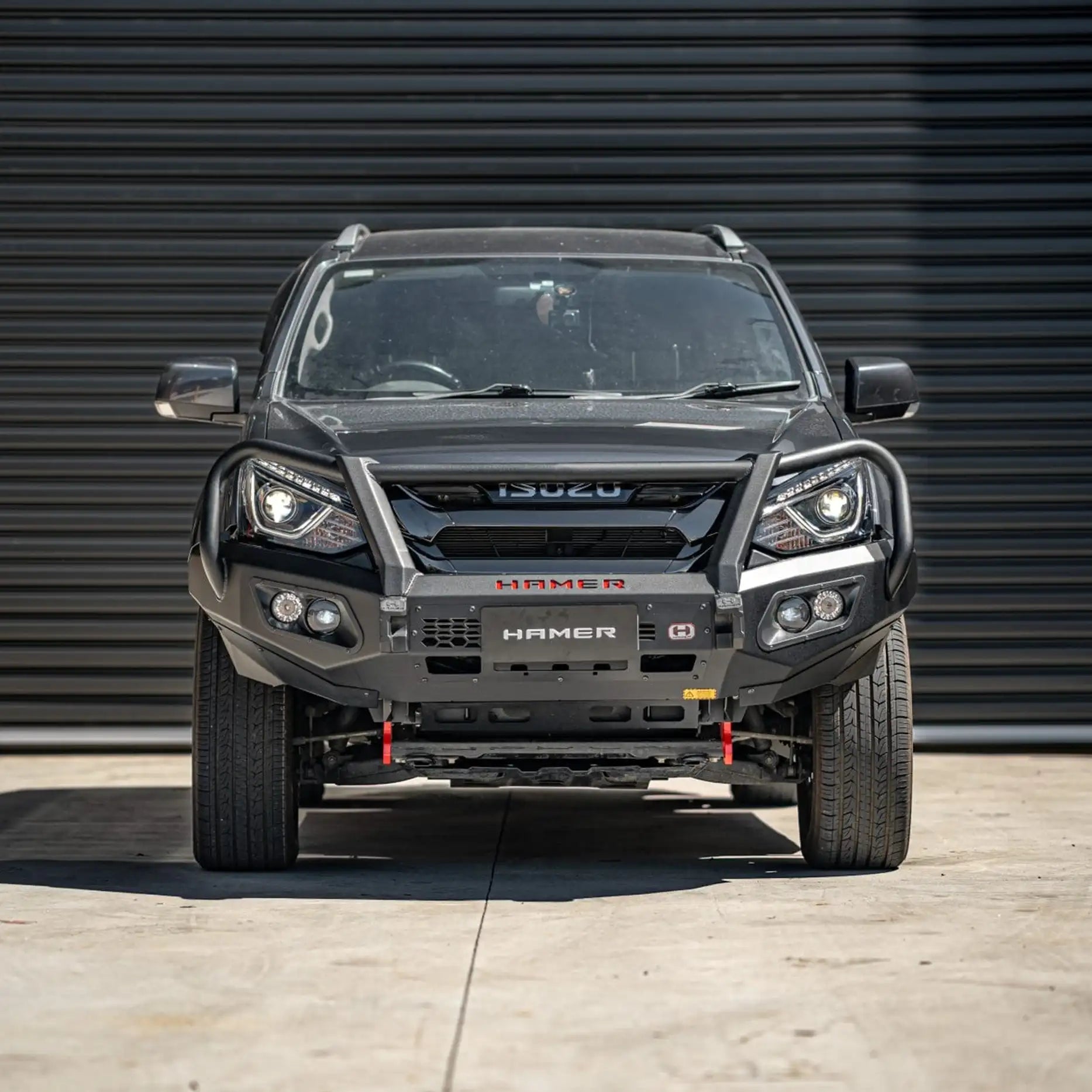 Front view of Isuzu MU-X 2016–2020 fitted with Hamer King Series Plus Bull Bar, featuring matte black powder-coated finish, ADR / Airbag compliance, and integrated LED lighting system for maximum visibility.
