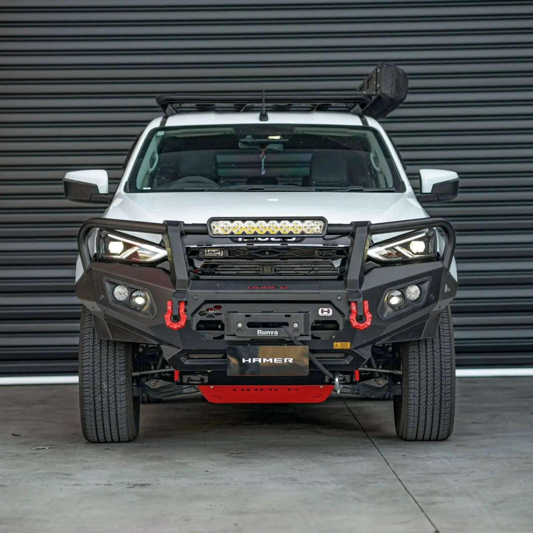 Front view of Isuzu MU-X 2021–2024 fitted with the Hamer King Series Plus Bull Bar, showing matte black powder-coated finish, ADR / Airbag compliance, and integrated LED lighting system.