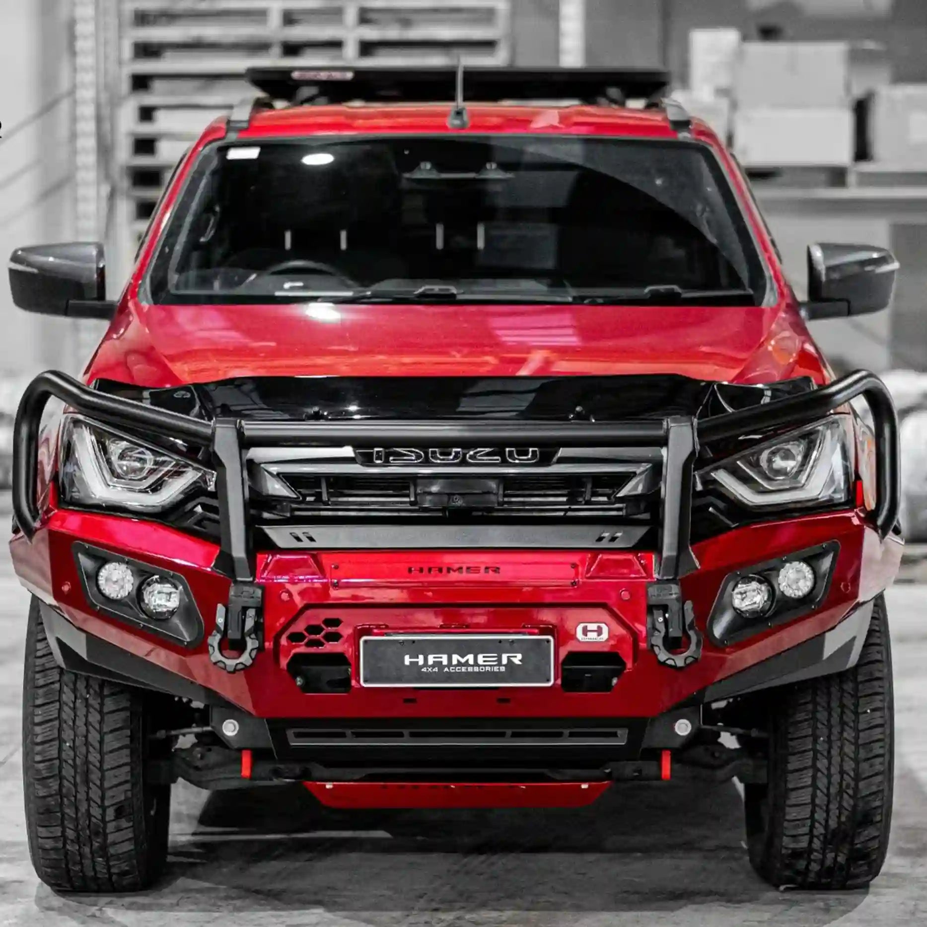 Close-up front perspective of the Isuzu D-Max (2021–2024) with the Hamer King Series Plus Bull Bar, highlighting light bar integration, number plate flip, and 3-piece splash guard.