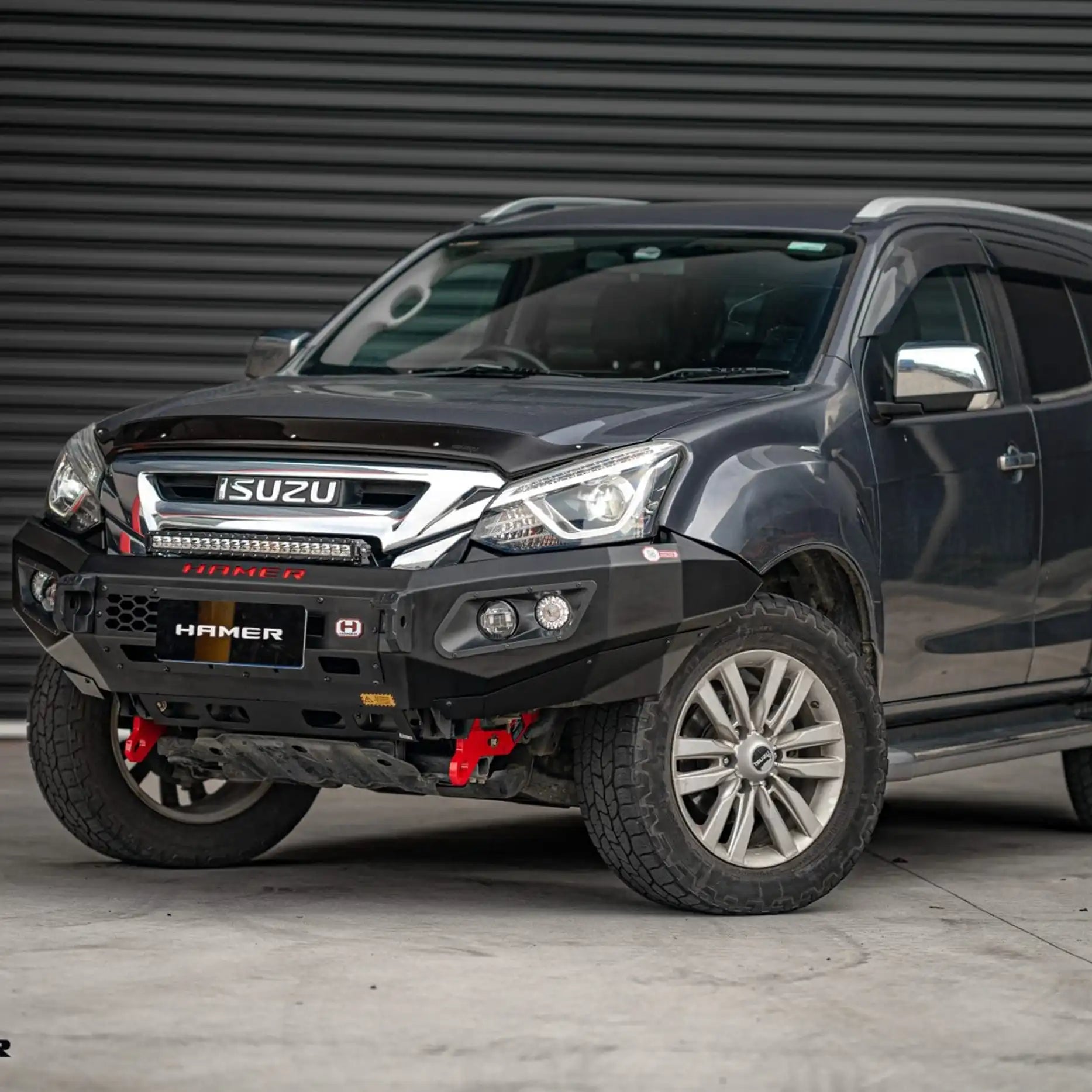 Right side angle of Isuzu MU-X 2016–2020 showcasing Hamer King Series Bull Bar with mounting points for extra lights and aerial, plus number plate flip for winch setups.