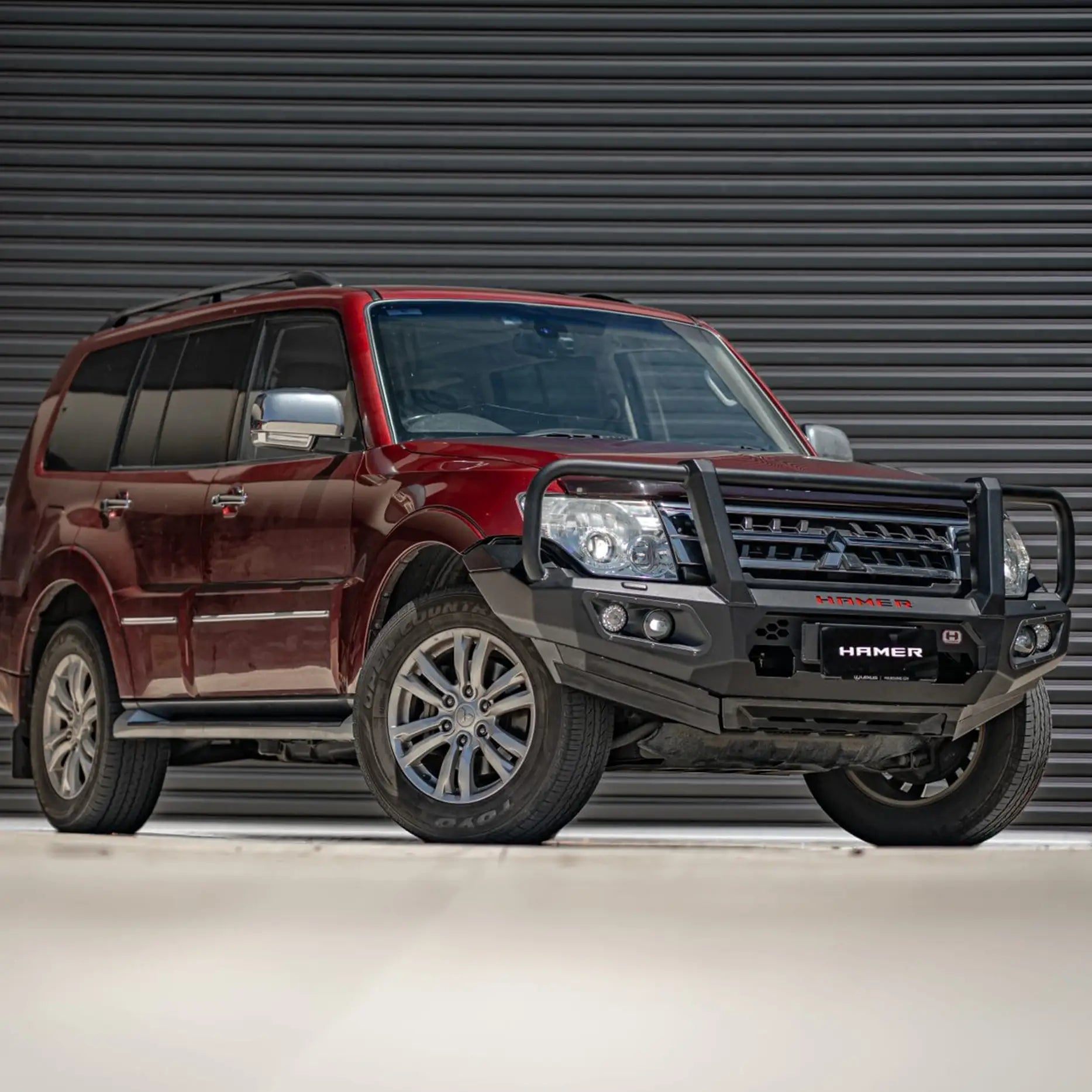 Left side view of Mitsubishi Pajero (2006–2021) showing Hamer King Series Plus Bull Bar, matte black finish with integrated LED lights and winch compatibility.