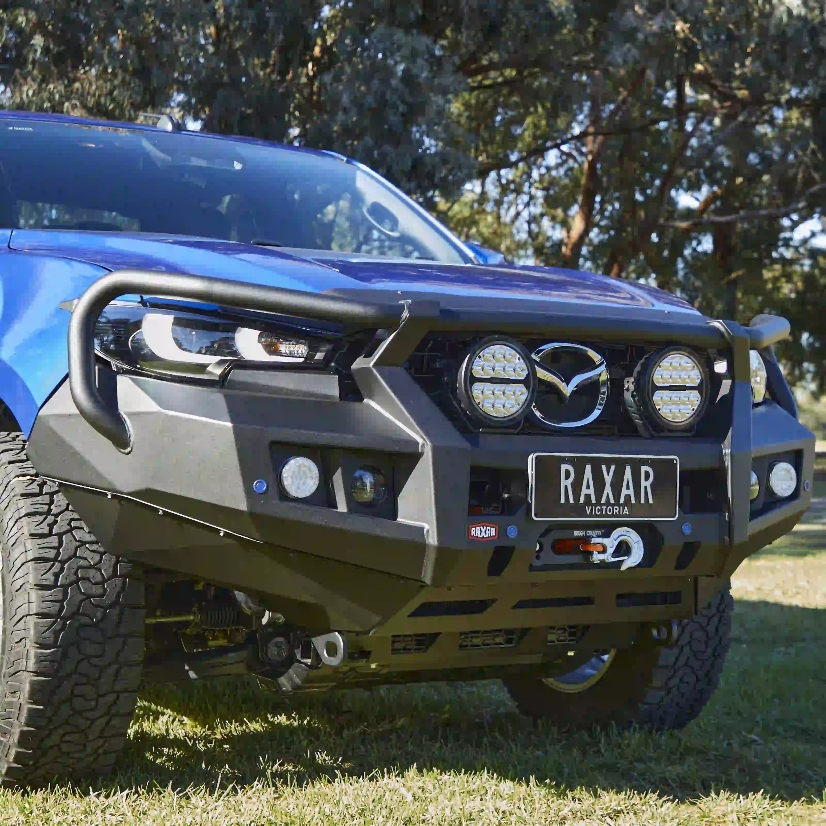 left side installed view of mazda bt50 2025 fitted with raxar looped bull bar showing integrated fog lights high lift jacking points and sleek airflow enhancing design built for city streets tough worksites and rugged australian touring conditions available from elevated 4x4