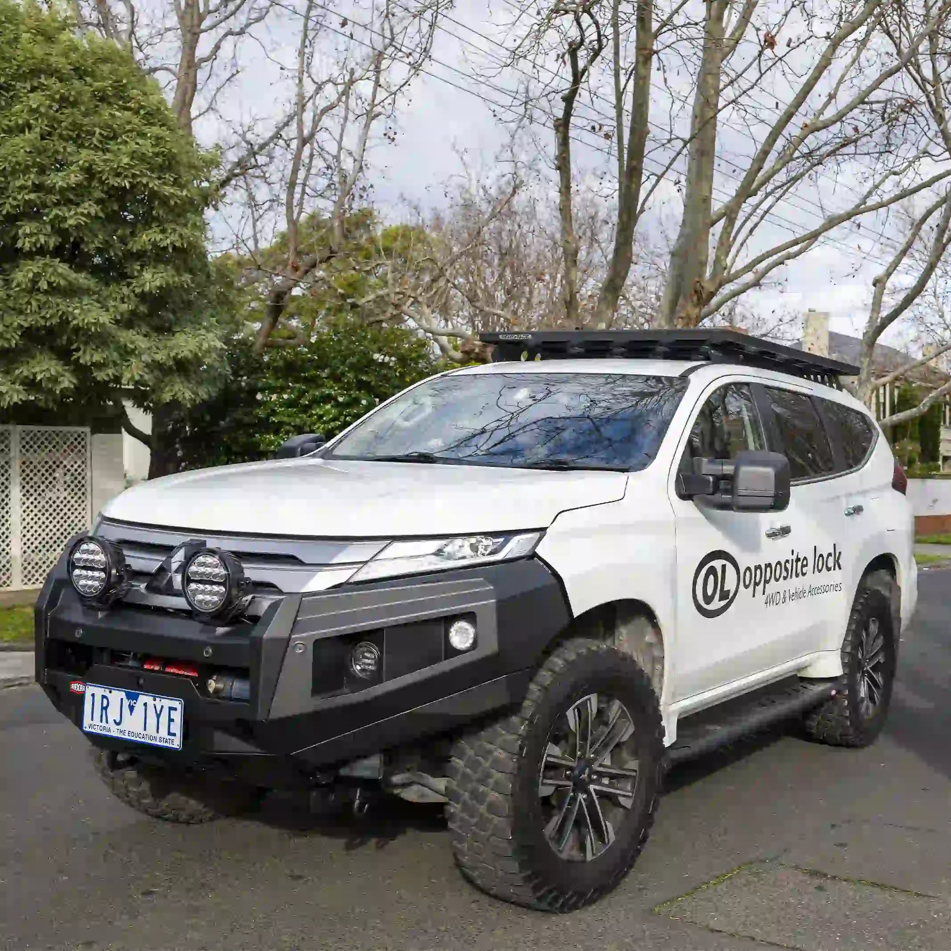 right side installed view of raxar no loop bull bar on mitsubishi pajero sport showing streamlined bumper replacement design integrated fog lights and airflow split pan strength designed for rugged australian conditions supplied by elevated 4x4
