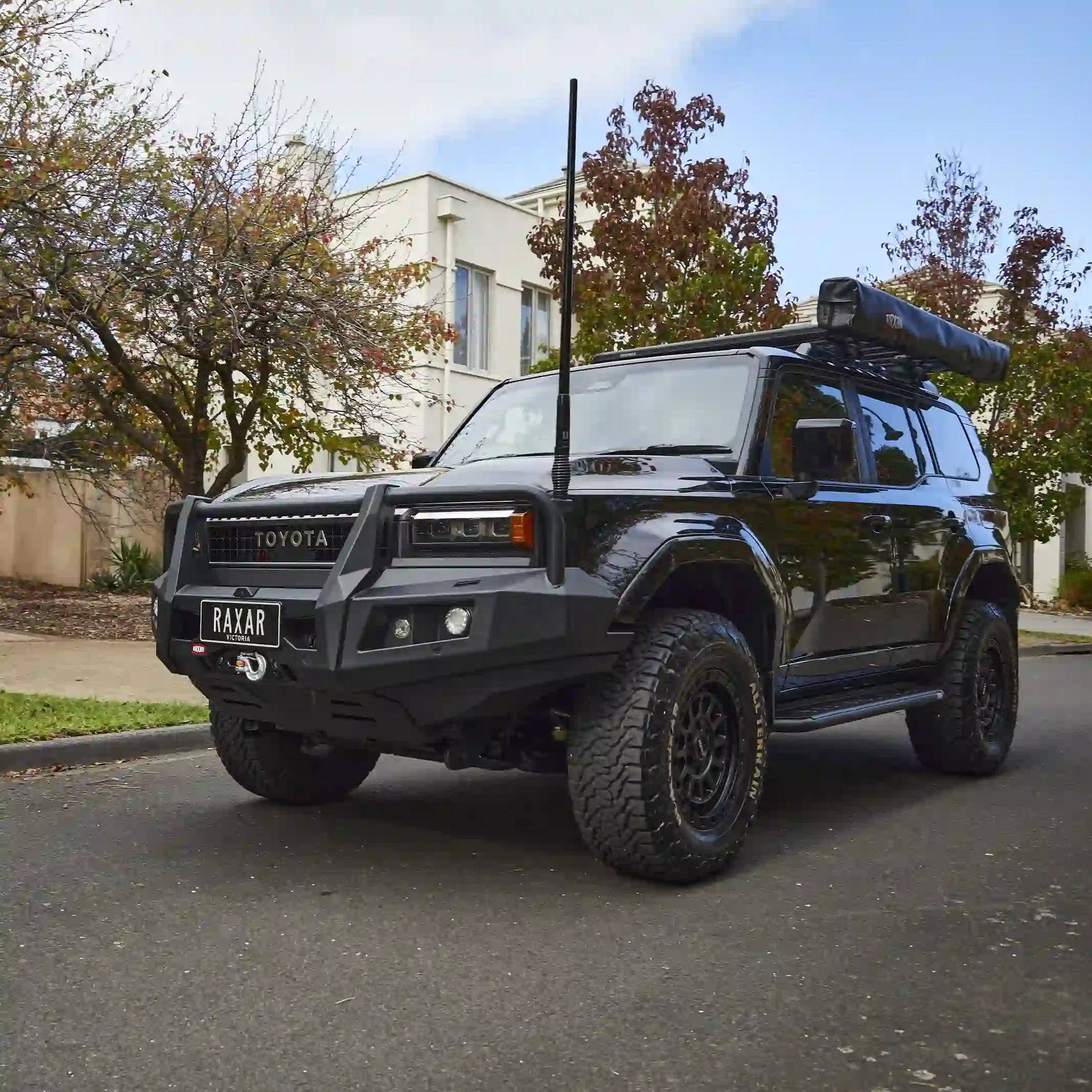 Captured from the right-side perspective, the Toyota Prado 250 looped bull bar installed by Elevated 4x4 emphasizes its robust RAXAR design with factory sensor integration, airflow efficiency, and high-lift jack points. Perfect for off-road adventures across Australia, it combines durability with premium styling.