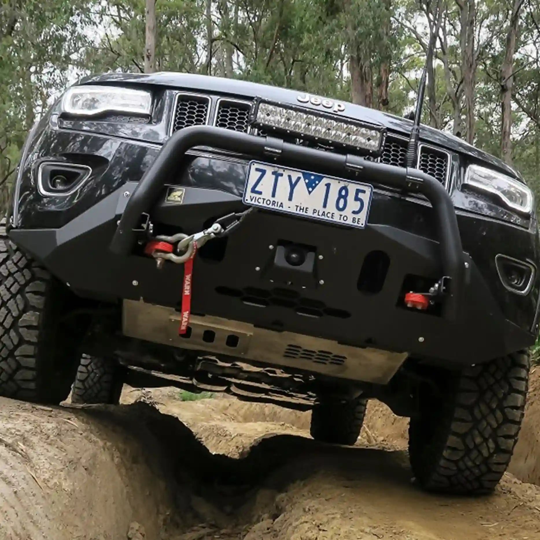 Jeep Grand Cherokee WK2 equipped with the Offroad Animal Nudge Bar in an off-road setting, showcasing the rated red tow hooks and 2.5-inch steel tubing. Built tough and fitted by Elevated 4x4, it delivers confidence and protection for adventurous drives through the Hunter Valley and Nelson Bay trails.