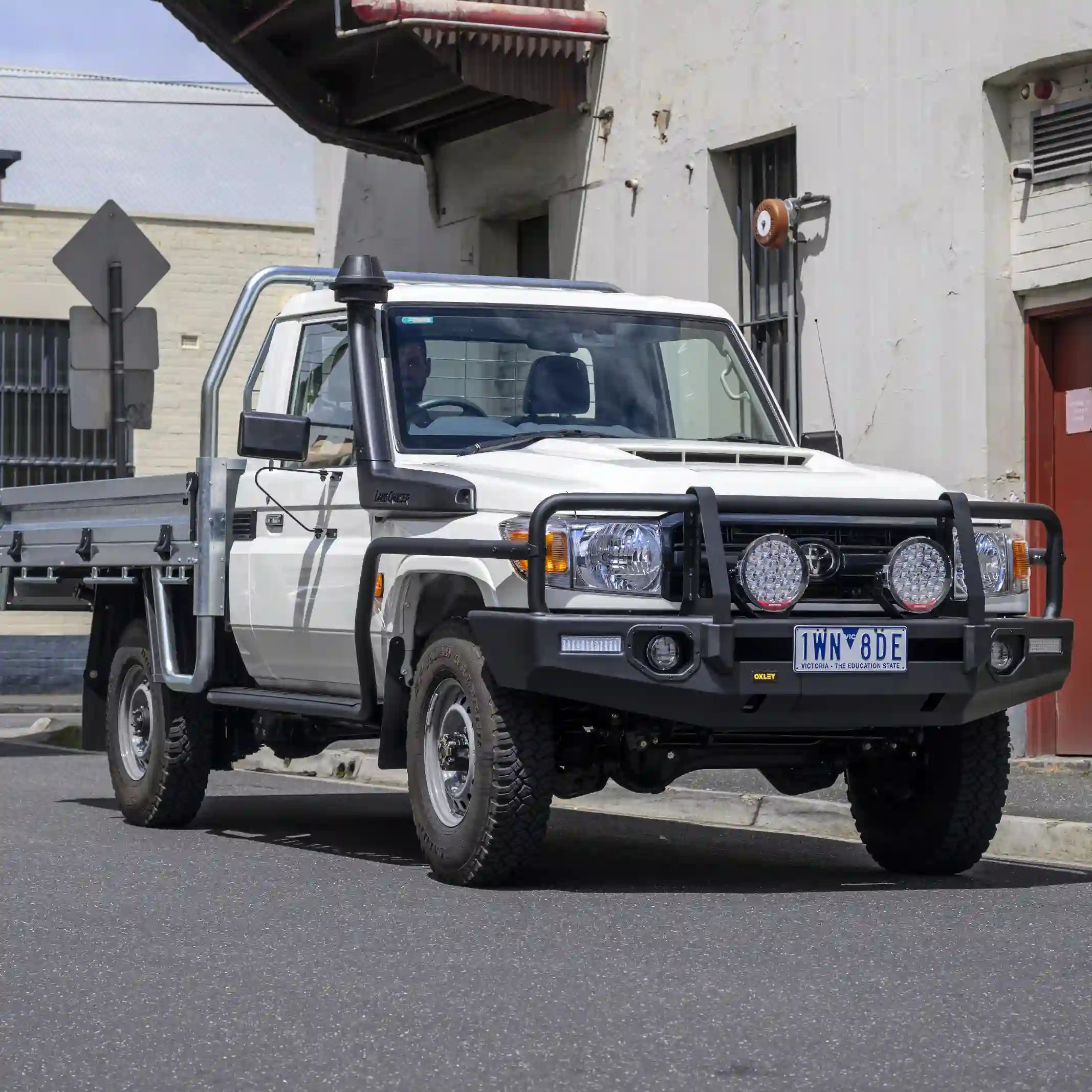 left installed oxley bull bar fitted to toyota lc70 single cab with winch compatibility and antenna tabs elevated 4x4