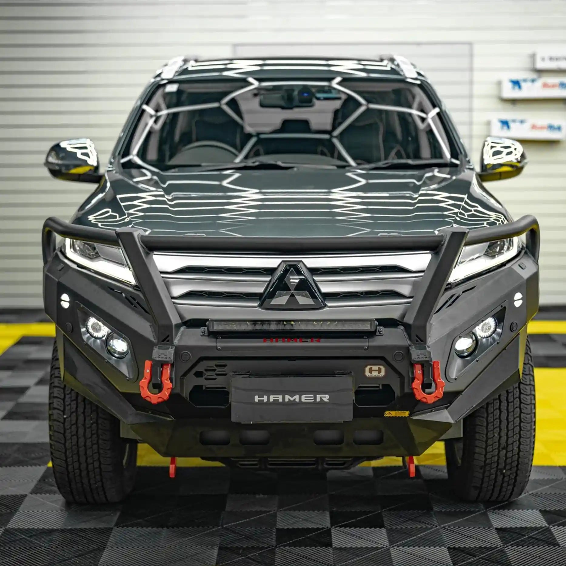 Front view of Mitsubishi Pajero Sport QG 2024 with Hamer King Plus Bull Bar, rugged matte black steel, winch compatible design.