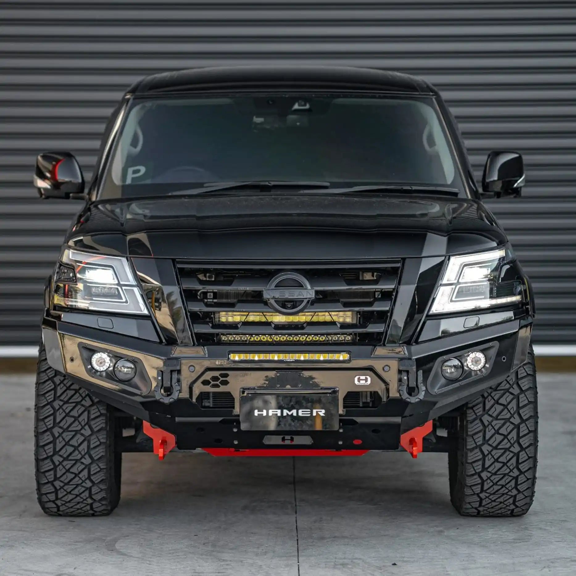 Front angle of Nissan Patrol Y62 Series 5 showing Hamer King Bull Bar with integrated LED lights and winch compatibility.