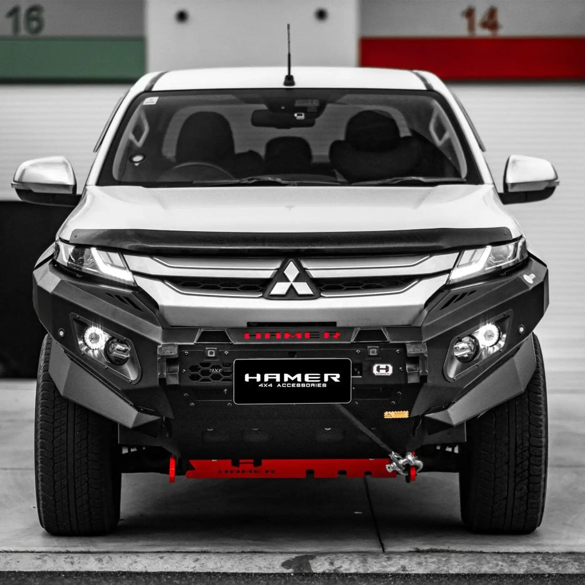 Closeup front display of Mitsubishi Triton MR (2018–Present) showcasing Hamer King Bull Bar, integrating parking sensors, lights, and camera relocation.