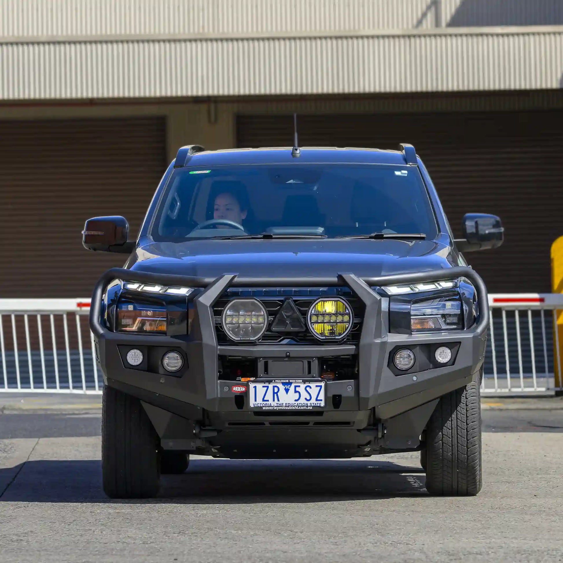 front installed view of raxar looped bull bar on mitsubishi triton mv featuring adr compliant bumper replacement design matte black powder coated finish fog lights recovery points and full winch compatibility engineered for australian conditions and available from elevated 4x4