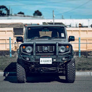 Front view of Suzuki Jimny JB74W with Hamer King Plus Bull Bar, ADR compliant matte black steel bar with integrated work lights and indicators.