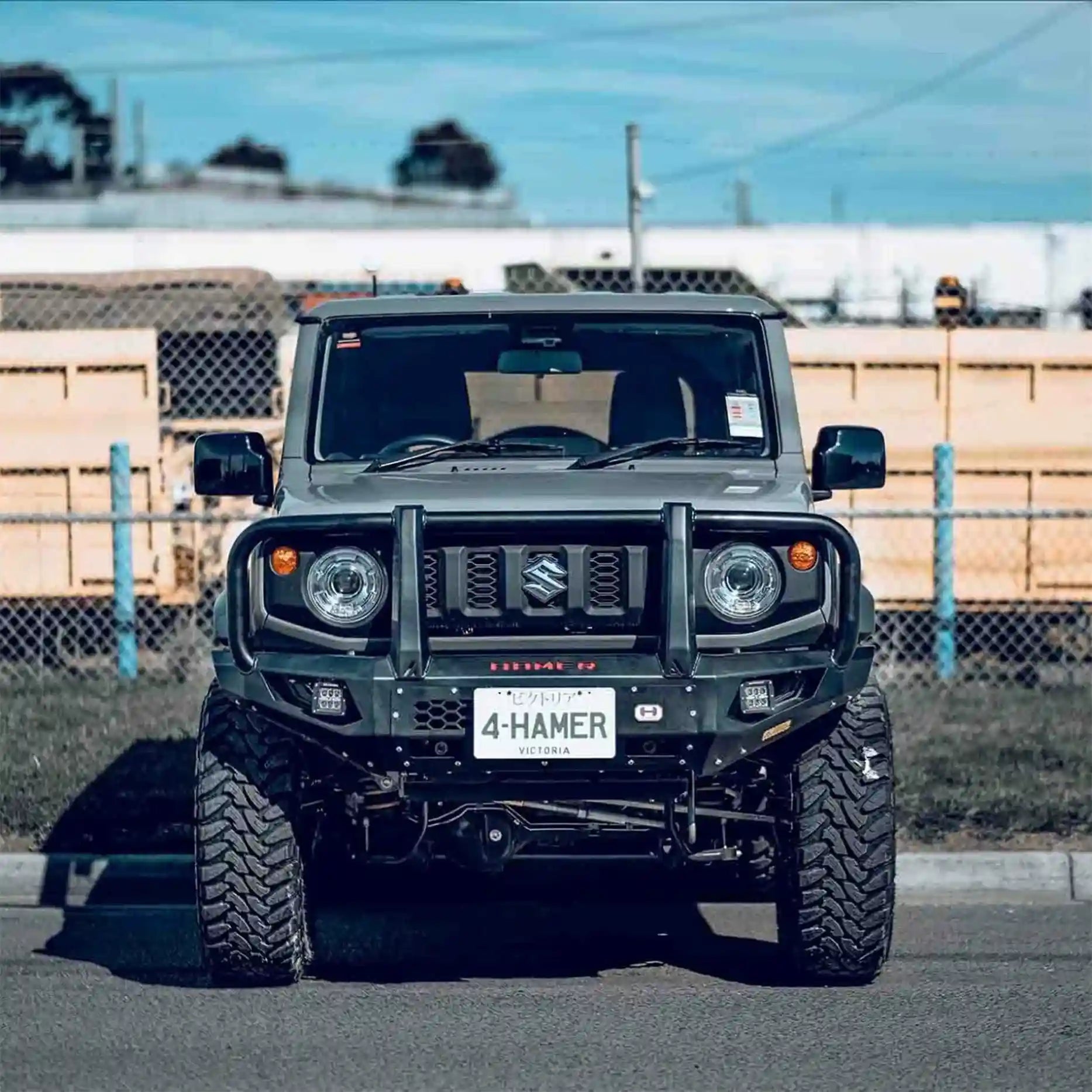 Front view of Suzuki Jimny JB74W with Hamer King Plus Bull Bar, ADR compliant matte black steel bar with integrated work lights and indicators.
