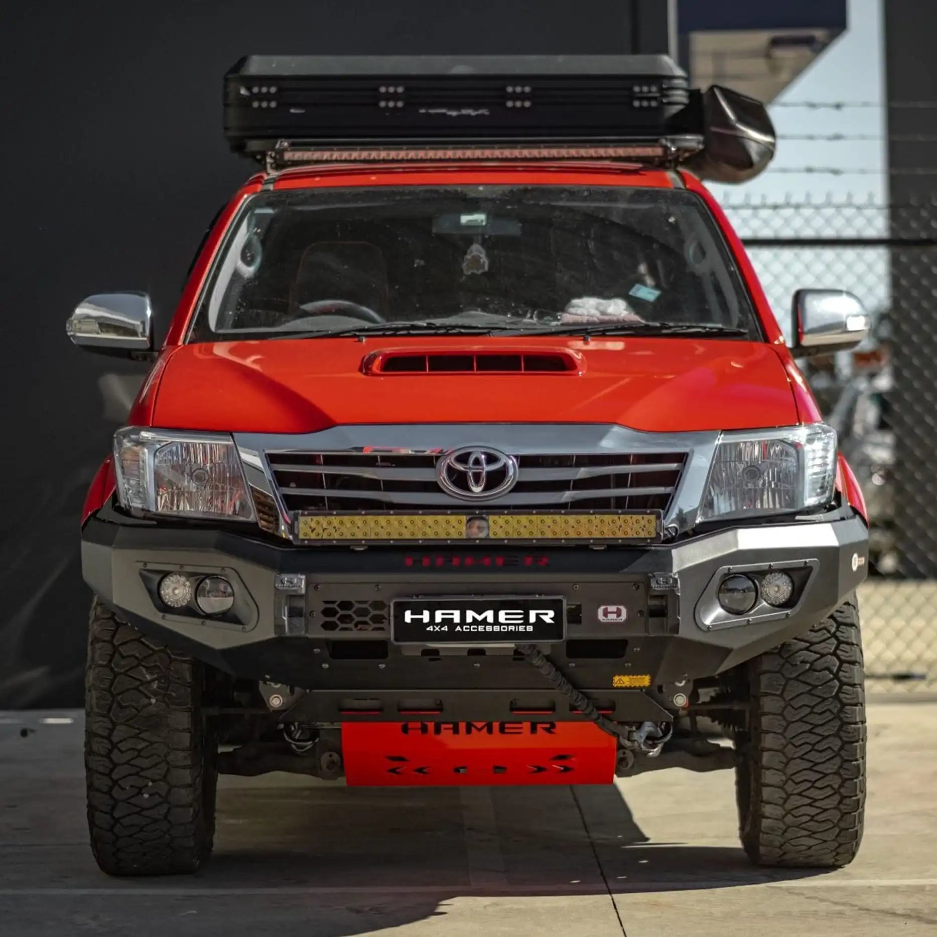 Off-road front shot of Hilux 2011–2015 with Hamer King Bull Bar, durable matte black finish, recovery points, E-Mark LED lighting.