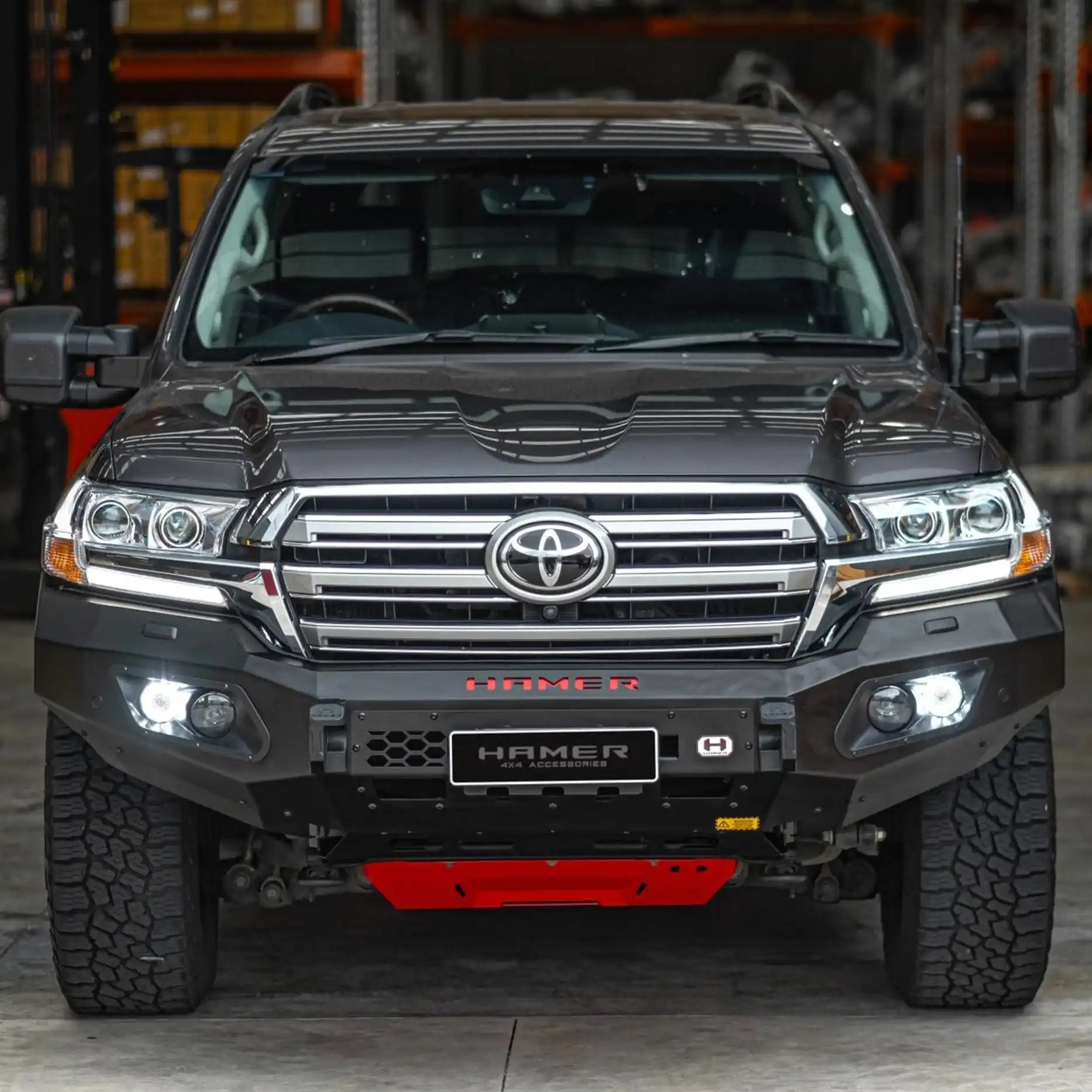 Angled front shot of Landcruiser 200 Series fitted with Hamer King Series Bull Bar, showing rugged 3 mm steel, matte black finish and LED lighting system.