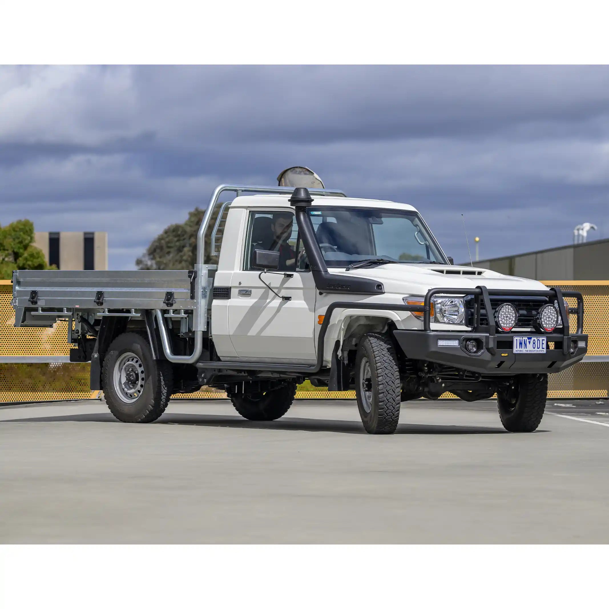 full body view toyota landcruiser 70 single cab fitted with oxley bull bar showing rugged 4wd stance elevated 4x4