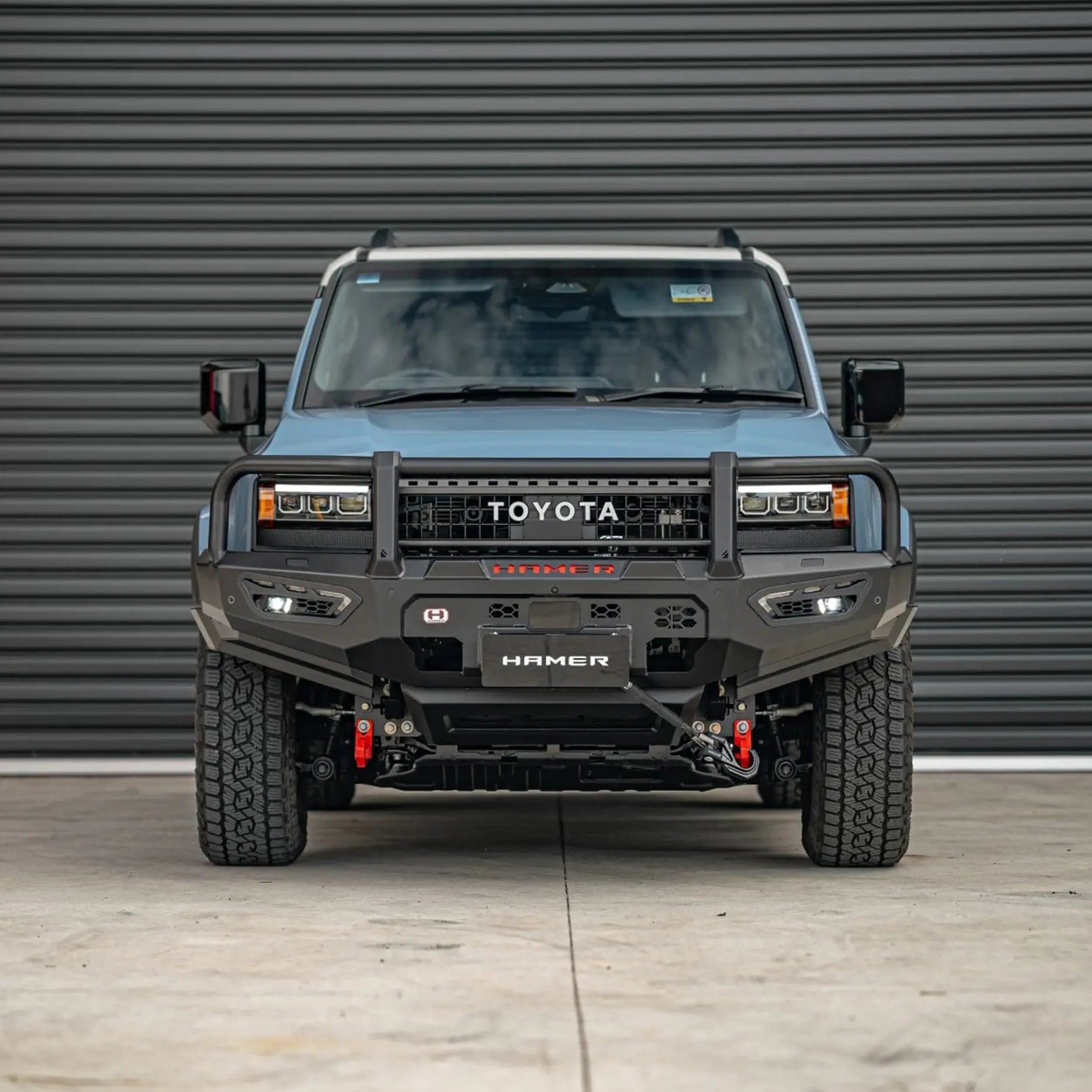 Front view of Hamer Atlas Plus Bull Bar fitted to Toyota Landcruiser Prado 250 Series 2024 – Present, showcasing full bumper replacement, ADR / Airbag compliance, and E-Mark certified LED lights.